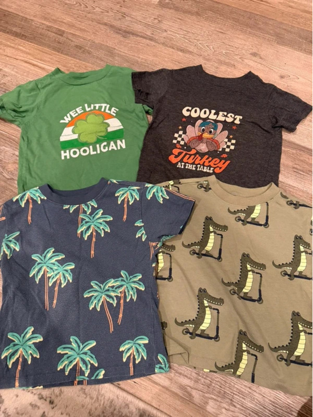 4 kids t-shirts with green palm trees on a dark blue background